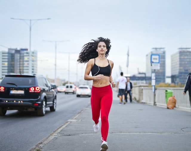photo-of-woman-listening-to-music-on-earphones-running-down